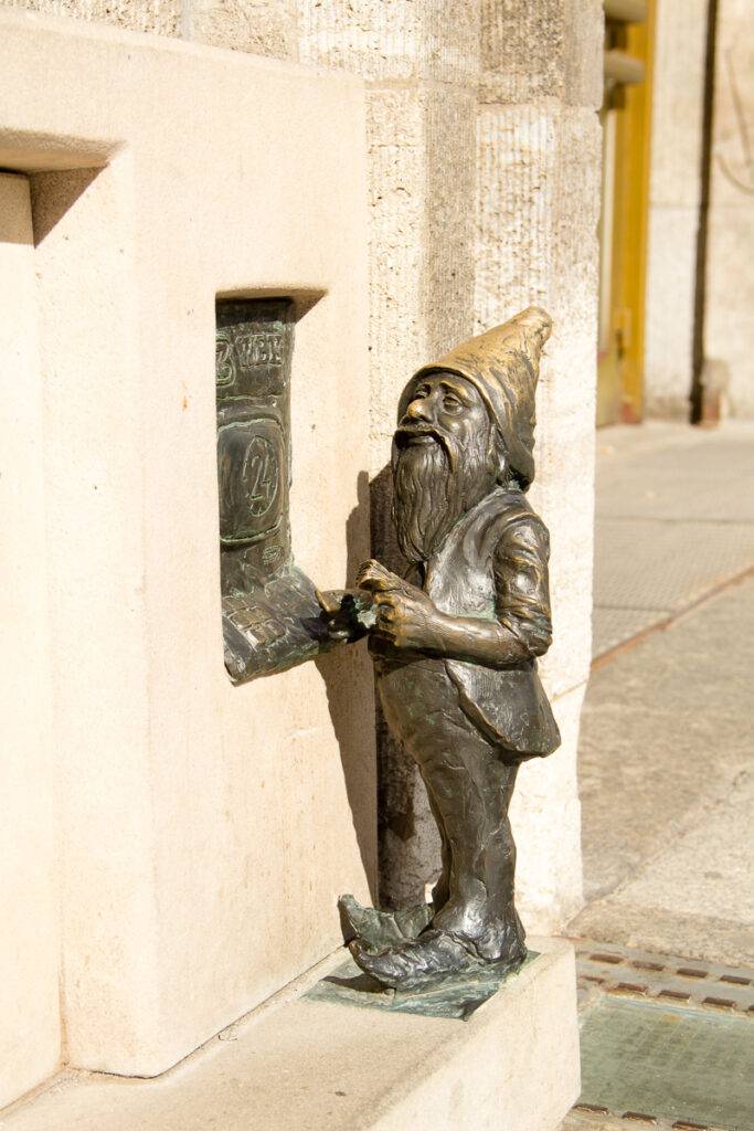 En bronsdvärg tar ut pengar i en minibankomat. Foto: ELISABET AXÅS