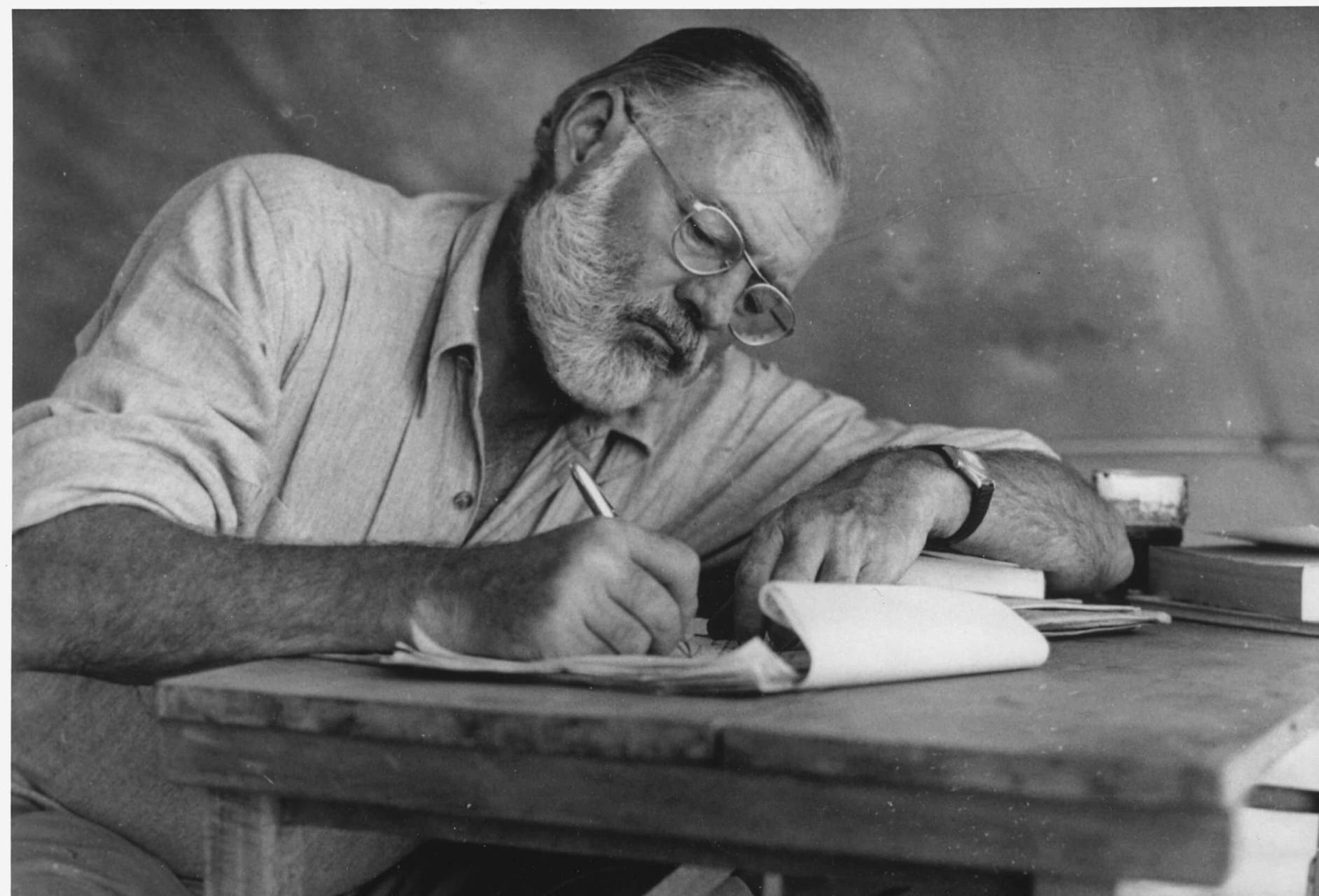 Hemingway lutad över ett anteckningsblock