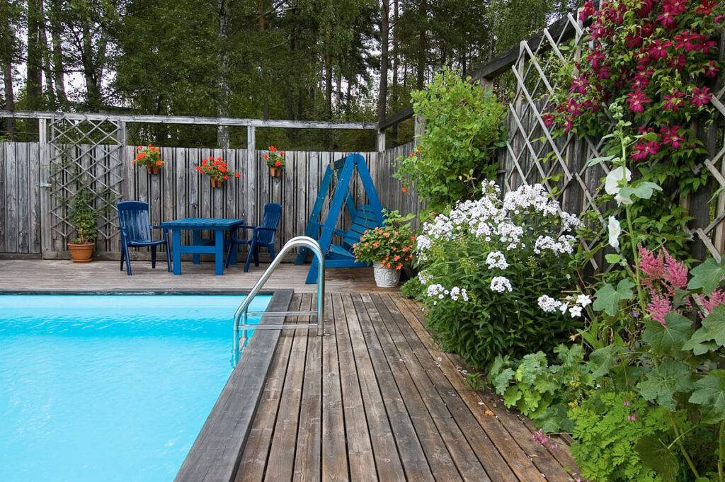 Ombonat skön atmosfär åstadkommet av växter vid plank och spaljé.